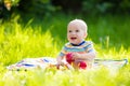 Baby boy with apple on family garden picnic Royalty Free Stock Photo