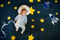 Baby boy is asleep and dreams himself an astronaut in space