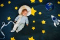 Baby boy is asleep and dreams himself an astronaut in space