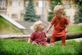 Baby boy and baby girl playing while sitting on green grass Royalty Free Stock Photo