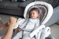 Baby boy being fed in his high chair at home Royalty Free Stock Photo