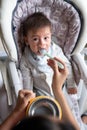 Baby boy being fed in his high chair at home Royalty Free Stock Photo