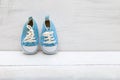 Baby boy blue sneakers on white wooden background Royalty Free Stock Photo