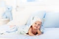 Baby boy in blue towel on white bed Royalty Free Stock Photo