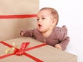 Baby boy in brown clothes singing Christmas carols by gift