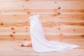 Baby boy with brown eyes is five months old wrapped in a white towel with ears on wooden background . Royalty Free Stock Photo