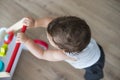 Baby boy playing with walking toy. Top view, indoor Royalty Free Stock Photo