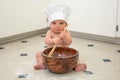 Baby Boy Chef with Blue Eyes Stirring in Bowl with Wooden Spoon Royalty Free Stock Photo