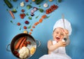 Baby boy in chef hat with cooking pan and vegetables Royalty Free Stock Photo