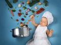 Baby boy in chef hat with cooking pan and vegetables Royalty Free Stock Photo