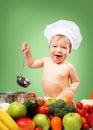 Baby boy in chef hat with cooking pan and vegetables Royalty Free Stock Photo