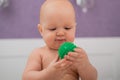 Baby boy chewing on a green massage ball. Royalty Free Stock Photo