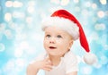 Baby boy in christmas santa hat over blue lights Royalty Free Stock Photo