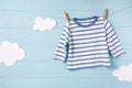 Baby boy clothes and cute white clouds on a clothesline, blue background Royalty Free Stock Photo