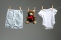 Baby boy clothes, a teddy bear on the clothesline Royalty Free Stock Photo