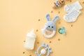 Baby boy concept. Top view photo of knitted bunny rattle toy blue teether wooden rattle milk bottle tiny socks pacifier and gold Royalty Free Stock Photo