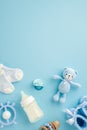 Baby boy concept. Top view vertical photo of milk bottle tiny socks knitted teddy bear toy blue knitted booties teether wooden Royalty Free Stock Photo