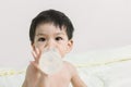 Baby Boy on the Couch is Eating the Milk from the Bottle with sp Royalty Free Stock Photo