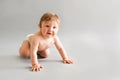 Baby boy crawling and laughing on grey background with a copy space Royalty Free Stock Photo