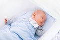 Baby boy in a crib under knitted blanket Royalty Free Stock Photo