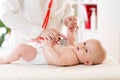 Baby boy in diaper during a medical. Doctor examines kid with stethoscope