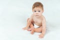 Baby boy in diaper sitting on bed in room. Portrait of cute toddler on white background, copy space.
