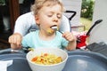 baby boy eating dinner outside house