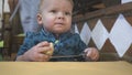 Baby boy eats bread in a restaurant