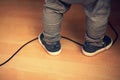 Baby boy feet standing on a power cord