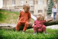 Baby boy and baby girl playing while sitting on green grass Royalty Free Stock Photo