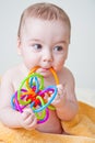 Baby Boy Gnawing Multicolored Toy on Yellow Towel Royalty Free Stock Photo