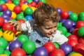 Baby boy having fun playing in a colorful plastic ball pool Royalty Free Stock Photo