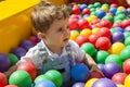 Baby boy having fun playing in a colorful plastic ball pool Royalty Free Stock Photo