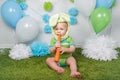 Baby boy in holiday Easter bunny rabbit costume with large ears, dressed in green clothes onesie, sitting on rug Royalty Free Stock Photo