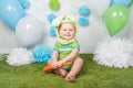 Baby boy in holiday Easter bunny rabbit costume with large ears, dressed in green clothes onesie, sitting on rug Royalty Free Stock Photo