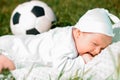 Baby boy infant fun photoshoot soccer football concept big smile having fun playing laughing laying on white furry round through s Royalty Free Stock Photo