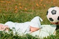 Baby boy infant fun photoshoot soccer football concept big smile having fun playing laughing laying on white furry round through s Royalty Free Stock Photo