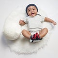 Baby boy infant fun photoshoot soccer football concept big smile having fun playing laughing laying on white furry round through s Royalty Free Stock Photo