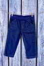 Baby boy jeans hanging on rope. Royalty Free Stock Photo