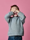 Baby boy kid covering close his eyes with hands and palms screaming laughing over pink Royalty Free Stock Photo