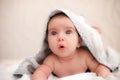 Baby boy is surprised and lies on his stomach in a towel with ears after bathing Royalty Free Stock Photo