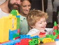 Baby boy looks at toy made out of construction blocks. Royalty Free Stock Photo