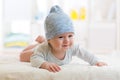 Baby boy lying on a children`s rug in blue cap. Royalty Free Stock Photo