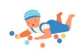 Baby boy lying and playing with colorful bright balls. Cute toddler having fun with toys. Scene of childish game or