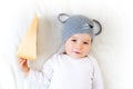 Baby boy in mouse hat lying on blanket with cheese Royalty Free Stock Photo
