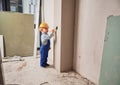 Baby boy painting wall in apartment under renovation. Royalty Free Stock Photo