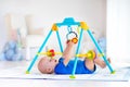 Baby boy on play mat. Child playing in gym.