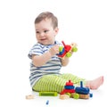 Baby boy playing with blocks toys looking away in surprise. Isolated on white. Royalty Free Stock Photo