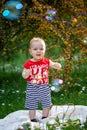 Baby boy playing with bubbles on sunny day in the garden. Child in the summer day catching soap bubbles Royalty Free Stock Photo