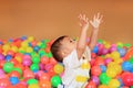 Baby boy playing with colorful plastic balls playground